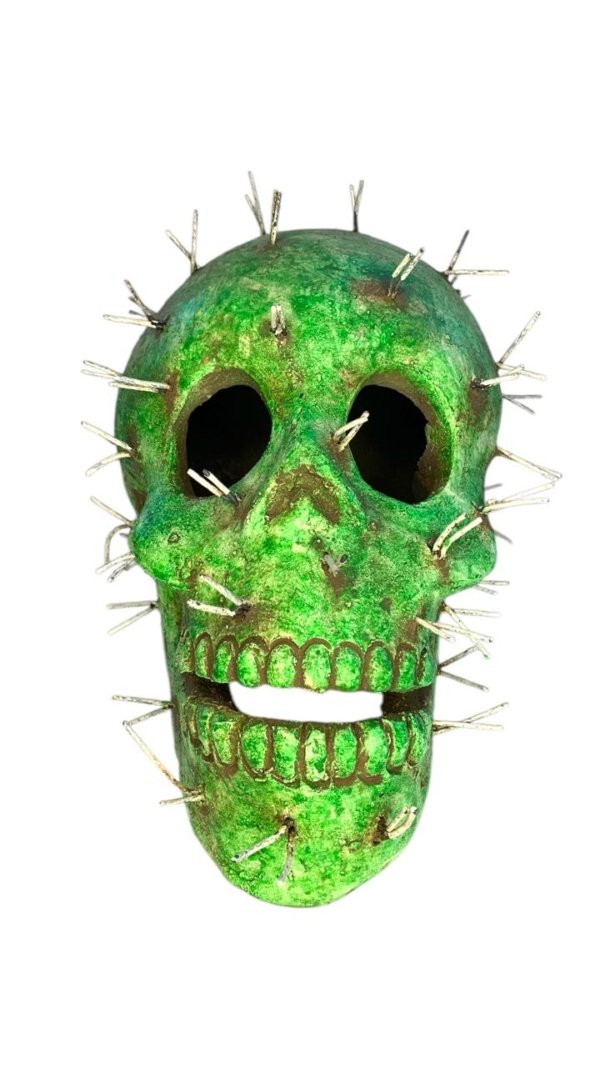Figura de craneo color verde con espinas encajadas
